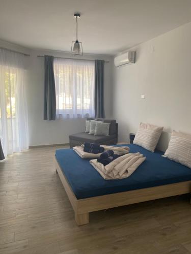 a bedroom with a bed with blue sheets and a couch at Villa Mara in Pula