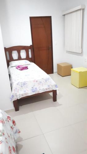 a bedroom with a bed and a wooden door at Pousada Recanto do Japa in Nilo Peçanha