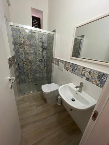 a bathroom with a shower and a sink and a toilet at B&B Regina Rooms in Avola