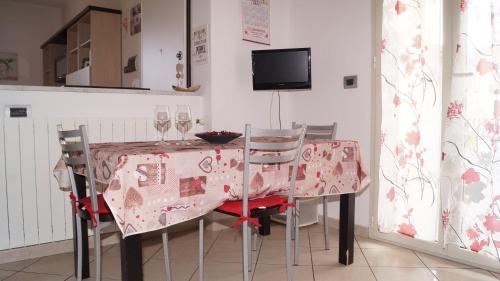 a dining room with a table with chairs and a tv at Bed and Breakfast da Nonna Ezia in Albenga