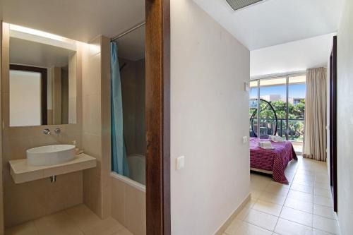 La salle de bains est pourvue d'un lavabo et d'un miroir. dans l'établissement Apartamento Herdade dos Salgados, à Guia