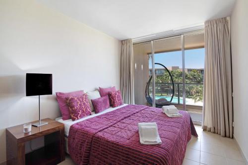 a bedroom with a large bed and a large window at Apartamento Herdade dos Salgados in Guia