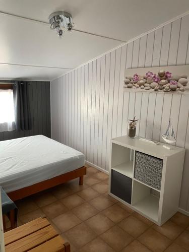 - une chambre avec un lit, une table et une étagère dans l'établissement Belle villa de vacances climatisée, residence TAMARIS, wifi, 2 chambres 4 à 6 couchages, accès payant pour les piscines et animations , PORTIRAGNES PLAGE LRTAMA57, à Portiragnes