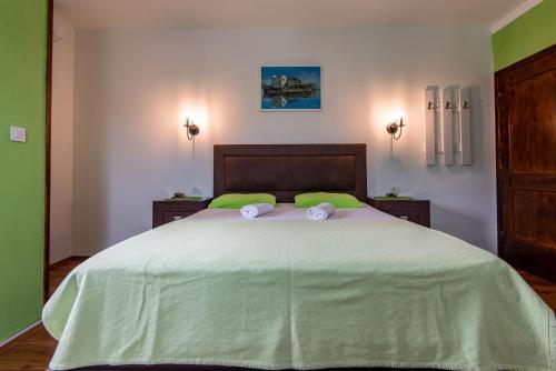 a bedroom with a large bed with two towels on it at Apartments and spa MIONA in Virpazar