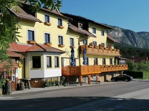 a large yellow building with a wooden balcony at Gasthof Mohr in Zweiersdorf