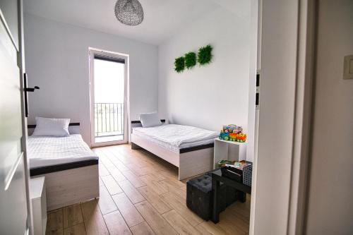 a room with two beds and a window at Apartament The Palm 35 by Housine in Zator