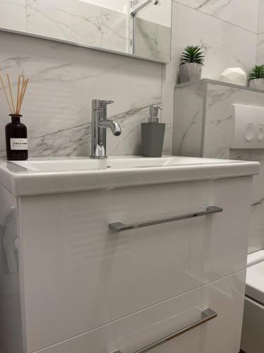 a white bathroom with a sink and a mirror at Apartment Meri in Korčula