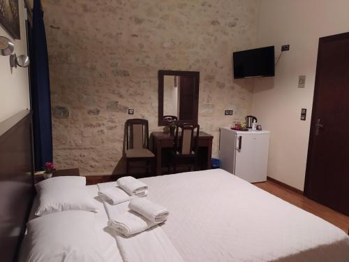 a bedroom with a large white bed and a table at Sea Front Old Town in Rethymno Town