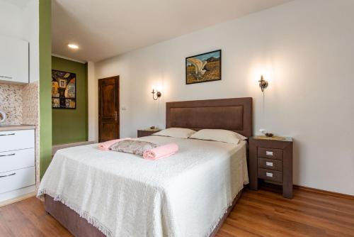 a bedroom with a large bed with a white blanket at Apartments and spa MIONA in Virpazar