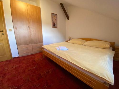 a bedroom with a large white bed in a room at Pension U Kostela in Frymburk