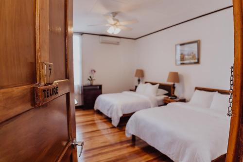 a hotel room with two beds and a door at Hotel Dunn Inn in San José