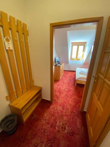 a room with a door and a bench in a room at Pension U Kostela in Frymburk
