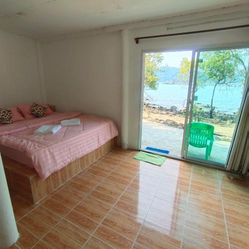 a bedroom with a bed and a large sliding glass door at Rasta view Bangalows in Ko Chang
