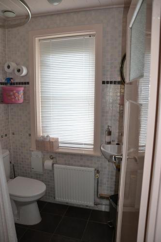 a bathroom with a toilet and a sink and a window at B&B MACBED CHECKIN-TIME 1700-1800 or request before you book in Alkmaar