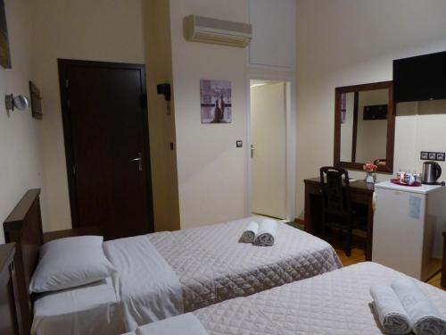 a hotel room with two beds and a mirror at Sea Front Old Town in Rethymno Town