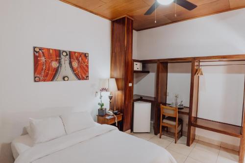 a bedroom with a bed and a couch and a clock on the wall at Hotel Dunn Inn in San José