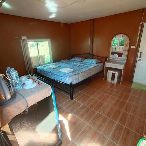 a small bedroom with a bed and a table at Rasta view Bangalows in Ko Chang