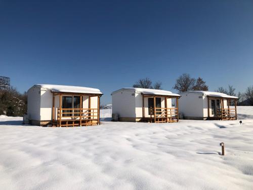 a group of three buildings in the snow at In Country Luxury Lodges in Camerino