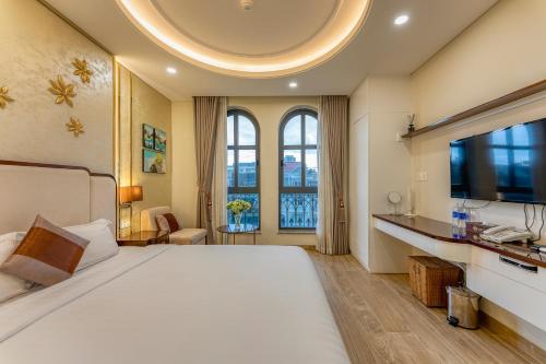 a bedroom with a large bed and a tv at Golden Tree Hotel & Apartment in Ho Chi Minh City
