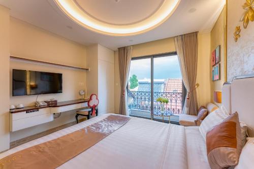 a bedroom with a large bed and a large window at Golden Tree Hotel & Apartment in Ho Chi Minh City