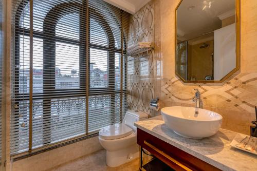 a bathroom with a sink and a toilet and a window at Golden Tree Hotel & Apartment in Ho Chi Minh City