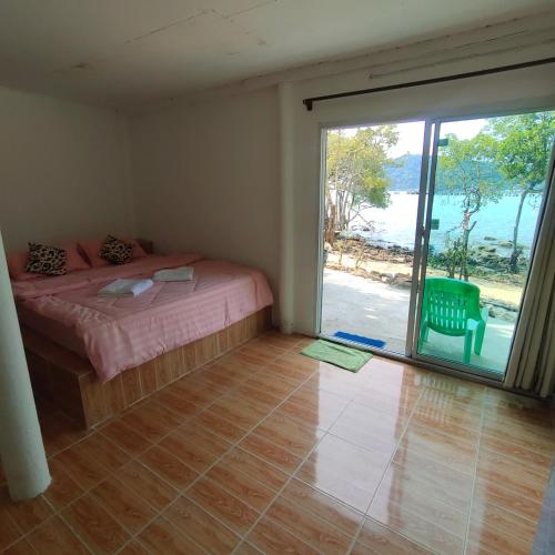 a bedroom with a bed and a large sliding glass door at Rasta view Bangalows in Ko Chang