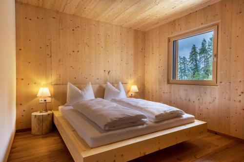 1 dormitorio con 1 cama en una pared de madera en Naturapartments Alpreid Fichte, en San Pancrazio