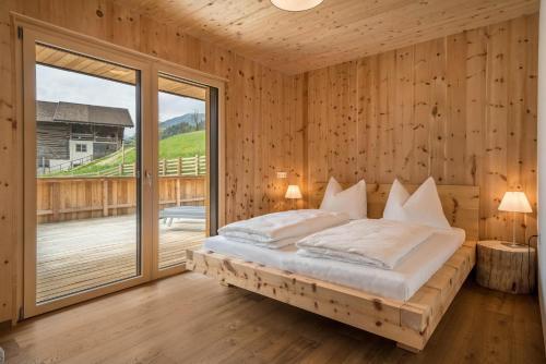 1 dormitorio con cama y ventana grande en Naturapartments Alpreid Zirbe, en San Pancrazio