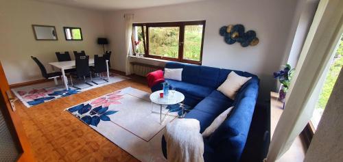 sala de estar con sofá azul y mesa en Ferienwohnung-Haustaedter-Muehle, en Lahnau