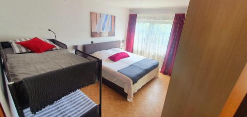 a bedroom with two beds and a window at Ferienwohnung-Haustaedter-Muehle in Lahnau