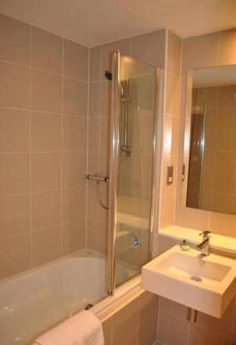 a bathroom with a tub and a sink and a shower at Dreamhouse Apartments Glasgow St Vincent Street in Glasgow