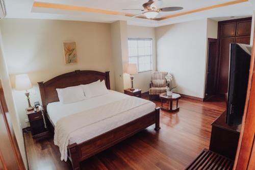 a bedroom with a bed and a flat screen tv at Hotel Dunn Inn in San José