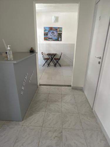 a hallway with a table and a tile floor at Regina Rooms in Avola