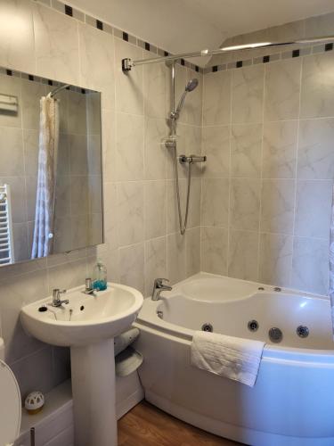 a bathroom with a bath tub and a sink and a bath tub at The Hay Suite in Aberystwyth