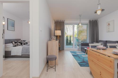 a living room with a kitchen and a living room with a bed at Osiedle Feniks Kołobrzeg by Renters in Kołobrzeg