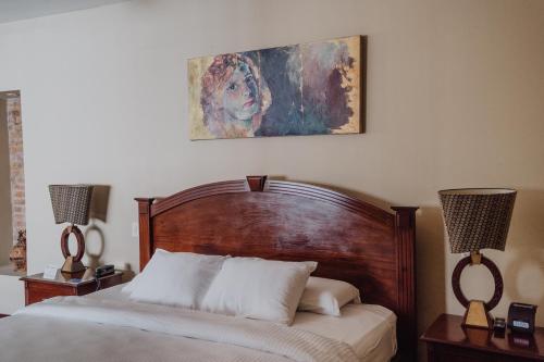a bedroom with a bed and a painting on the wall at Hotel Dunn Inn in San José