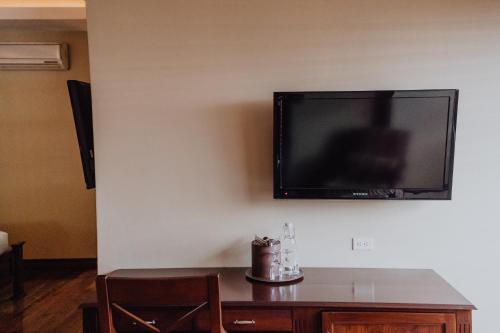 a flat screen tv hanging on a wall at Hotel Dunn Inn in San José