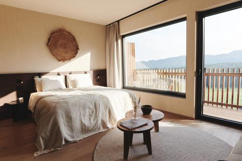 a bedroom with a large bed and a large window at Boutiquehotel DAS ZEITWERT in Deutschlandsberg