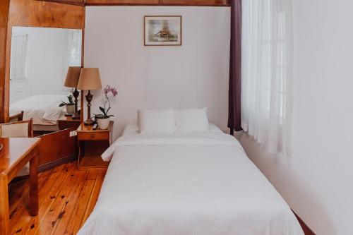 a bedroom with two beds and a table and a desk at Hotel Dunn Inn in San José