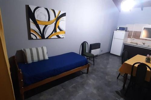 a small room with a blue bed and a table at Departamento WerMa !!!! in El Calafate