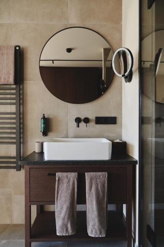 a bathroom with a sink and a large mirror at Boutiquehotel DAS ZEITWERT in Deutschlandsberg