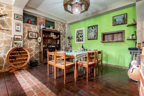 een eetkamer met groene muren en een tafel en stoelen bij Apartments MIONA in Virpazar