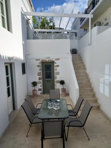 a patio with a table and chairs and stairs at FAMILY in Spetses