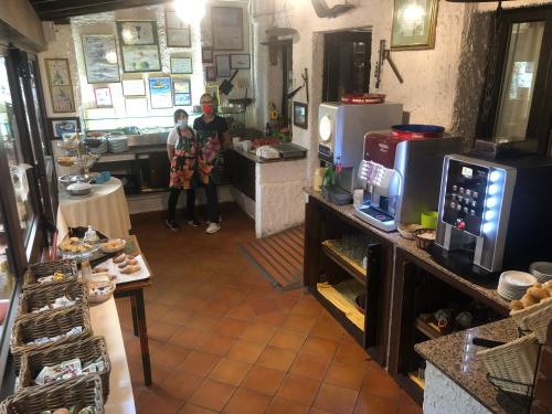 a kitchen with two people standing in a kitchen at Hotel da Peppe in Letojanni