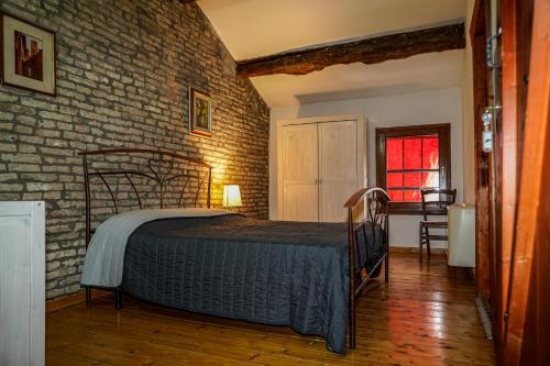 a bedroom with a bed and a brick wall at La Locanda degli Artisti in Medelana