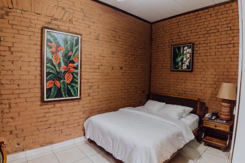 a bedroom with a bed and a brick wall at Hotel Dunn Inn in San José