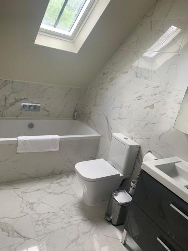a white bathroom with a toilet and a sink at Stunning home with hot tub in picturesque village in Haddenham
