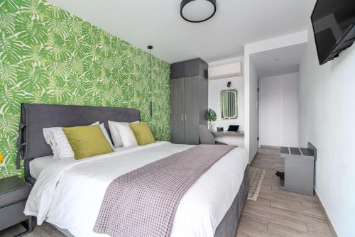 a bedroom with a large bed and a green wall at Maison 66, Riviera Hotels in Athens