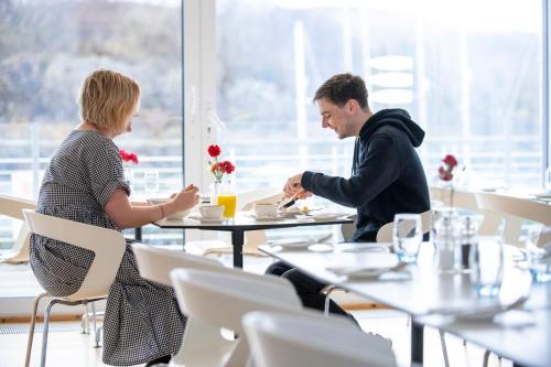 a man and woman sitting at a table in a restaurant at Portavadie Loch Fyne Scotland in Portavadie