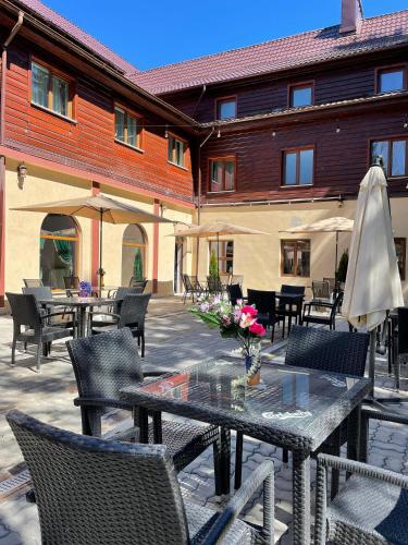 a patio with a table and chairs and a building at Voila Inn Predeal in Predeal